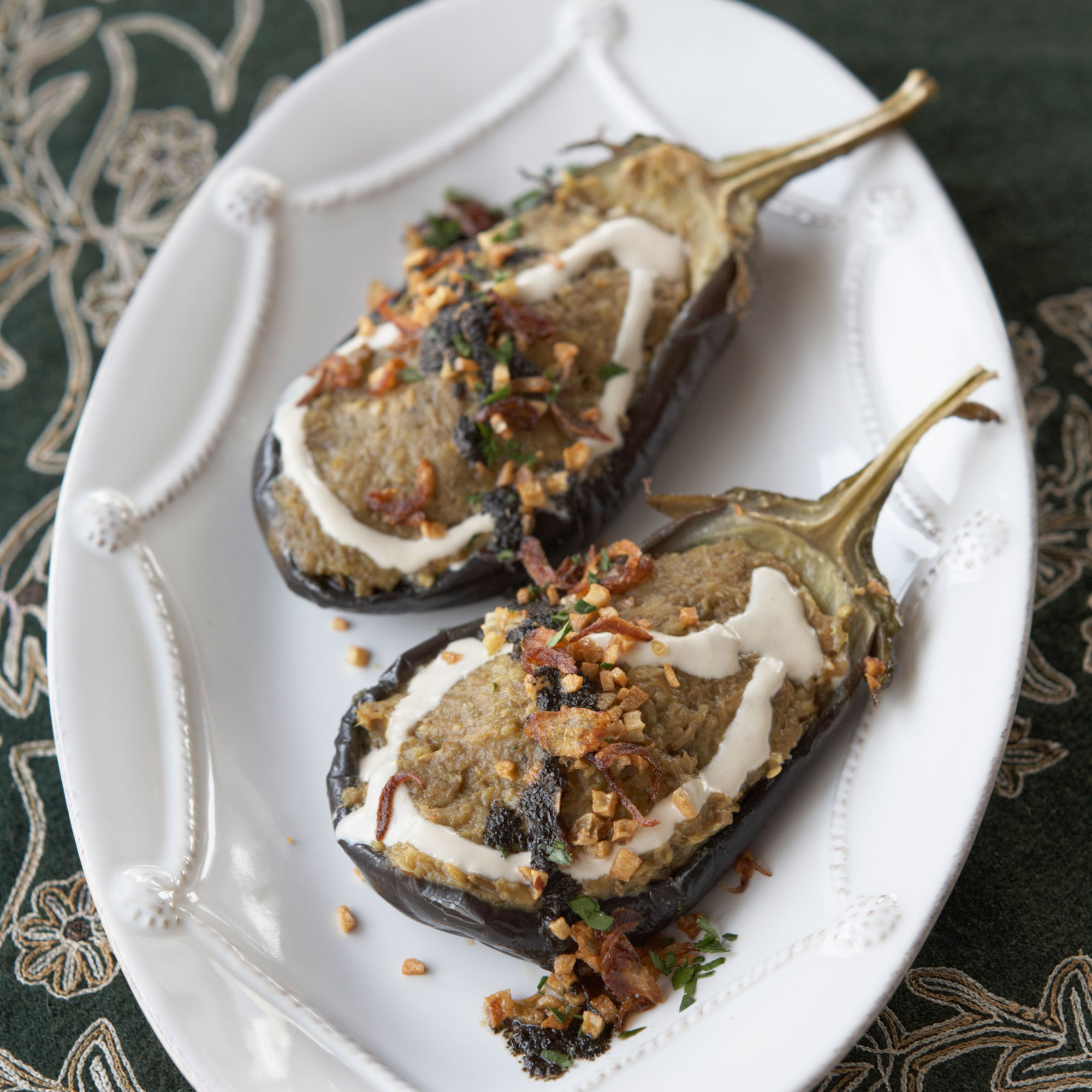 Grilled aubergine spread topped with creamy whey, fried onions, garlic, mint and walnuts recipe Grilled aubergine spread topped with creamy whey, fried onions, garlic, mint and walnuts recipe