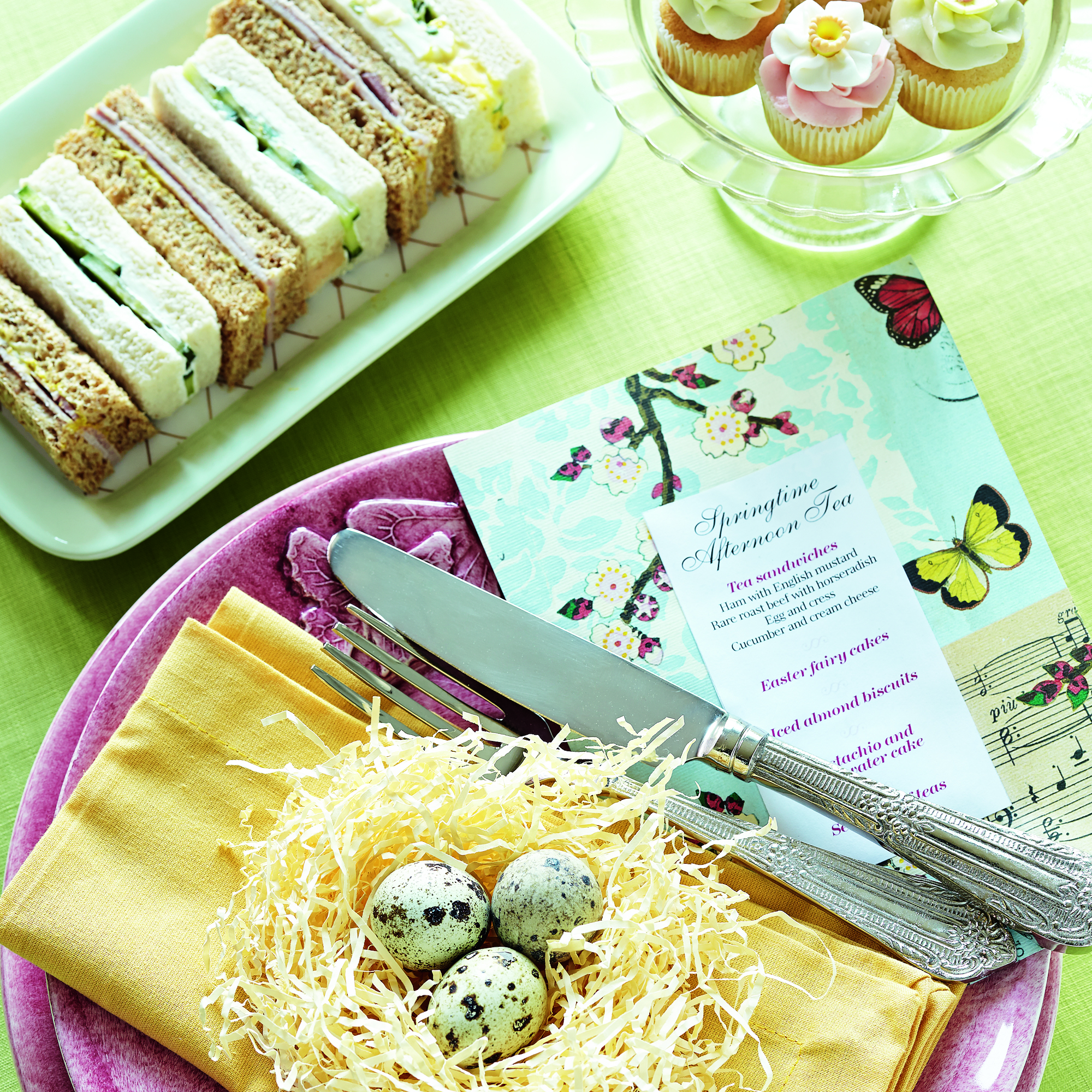 place setting with sandwiches and cupcakes photo